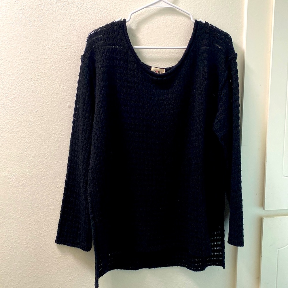 Black knit sweater that is long on the back.